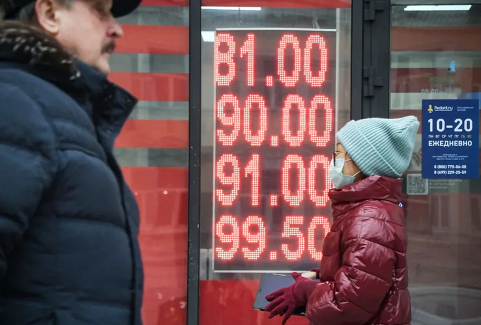 People walk past a currency exchange in Moscow, Russia
