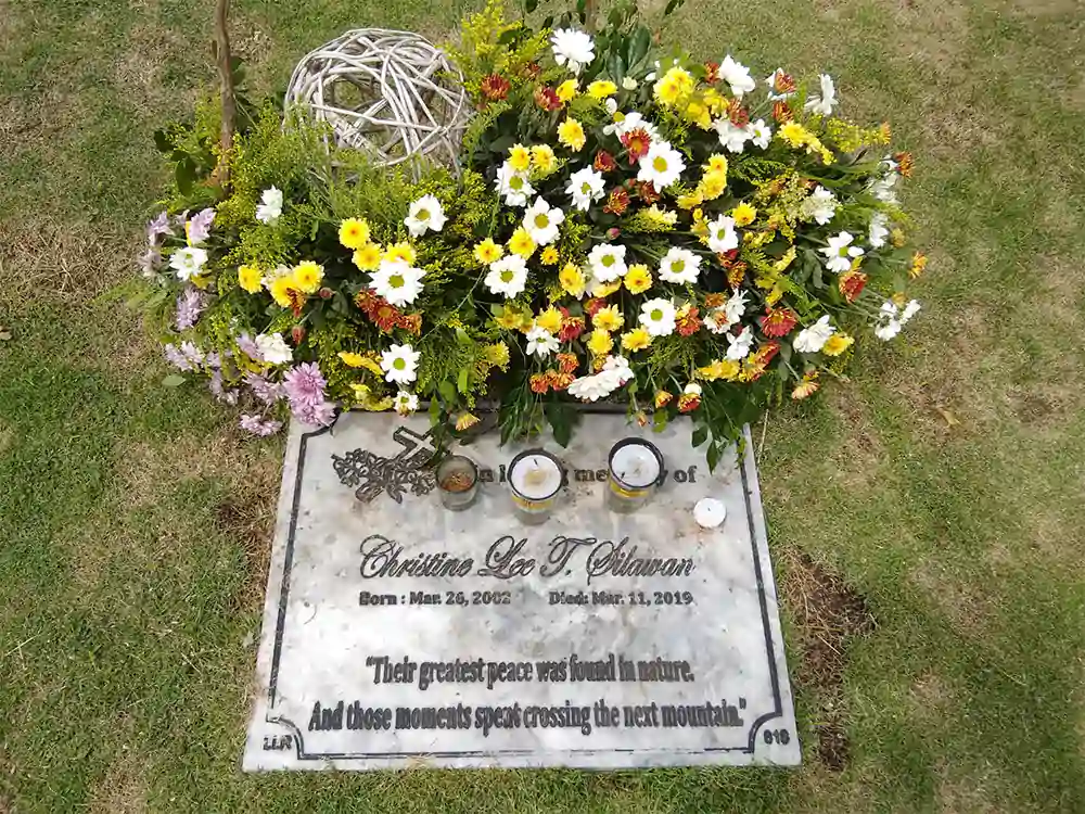 Flowers and candles are placed on the tomb of Christine Lee Silawan at the Cattleya Cemetery in the town of Cordova