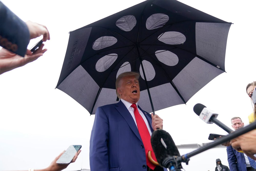 Former U.S. President Donald Trump speaks to reporters at Ronald Reagan Washington National Airport