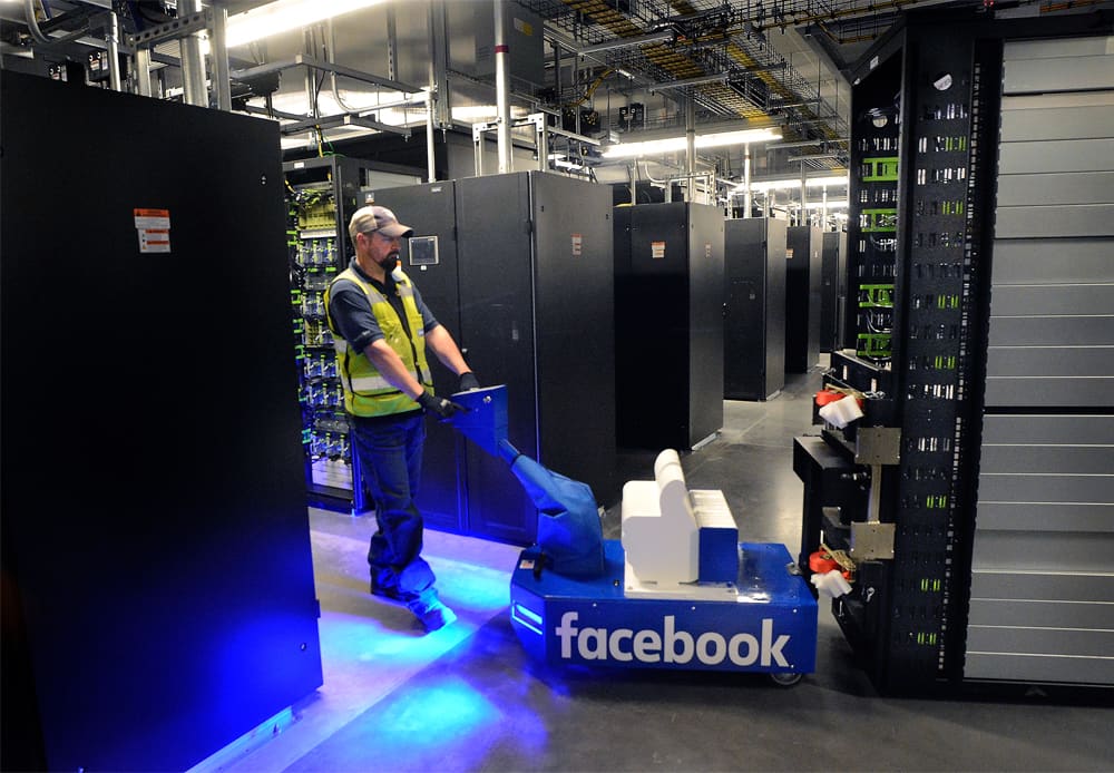 A logistics specialist moves a server rack in one of the data halls at Facebook's data center in Los Lunas, New Mexico.