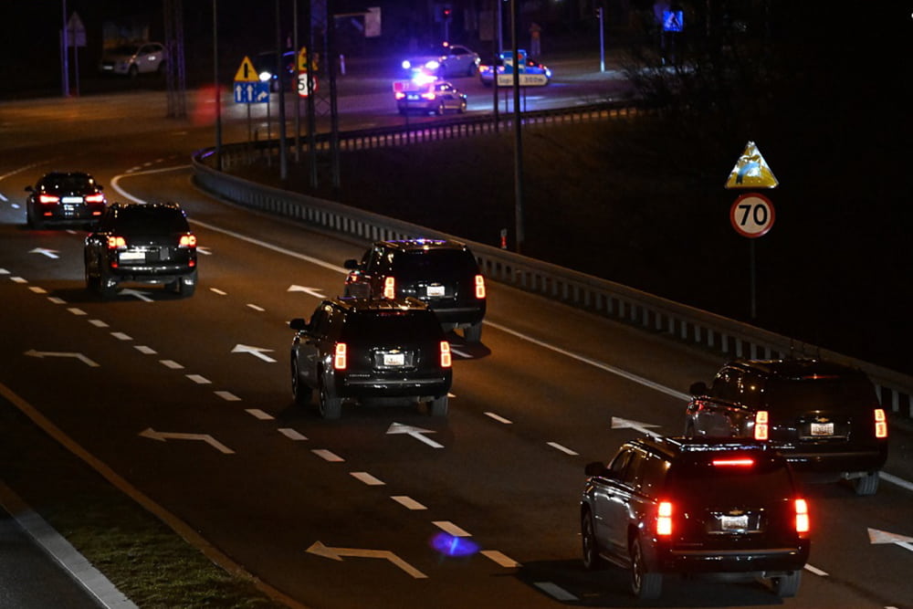 U.S. President Joe Biden motorcade consists of black SUVs. The car he is driven in has no flags.