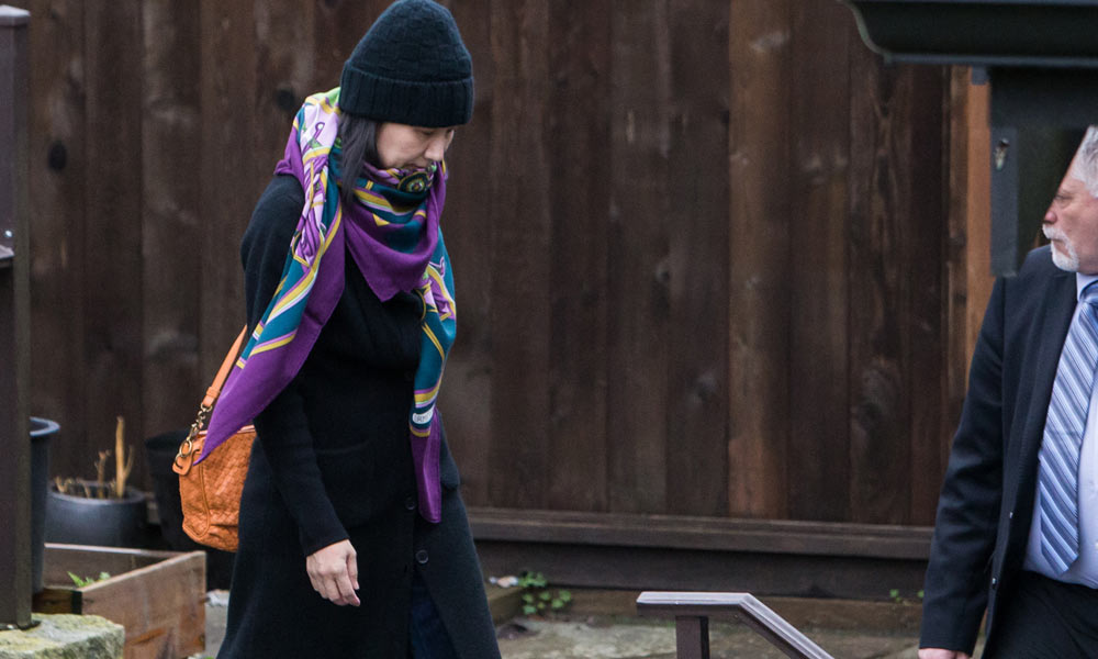 Meng Wanzhou leaves her house in Vancouver, Canada, under the supervision of a security guard