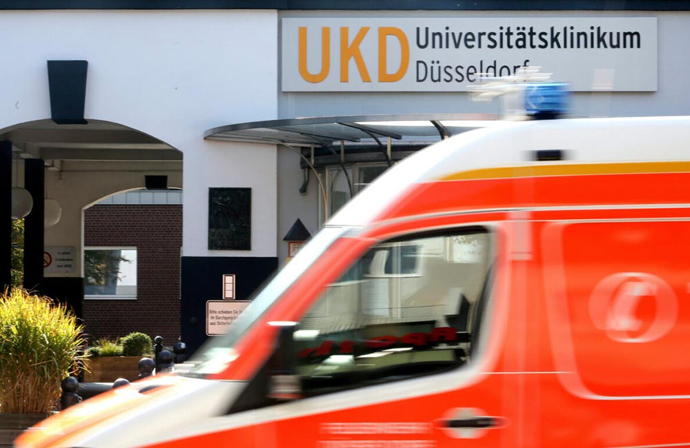 An ambulance drives past the University Hospital of Düsseldorf